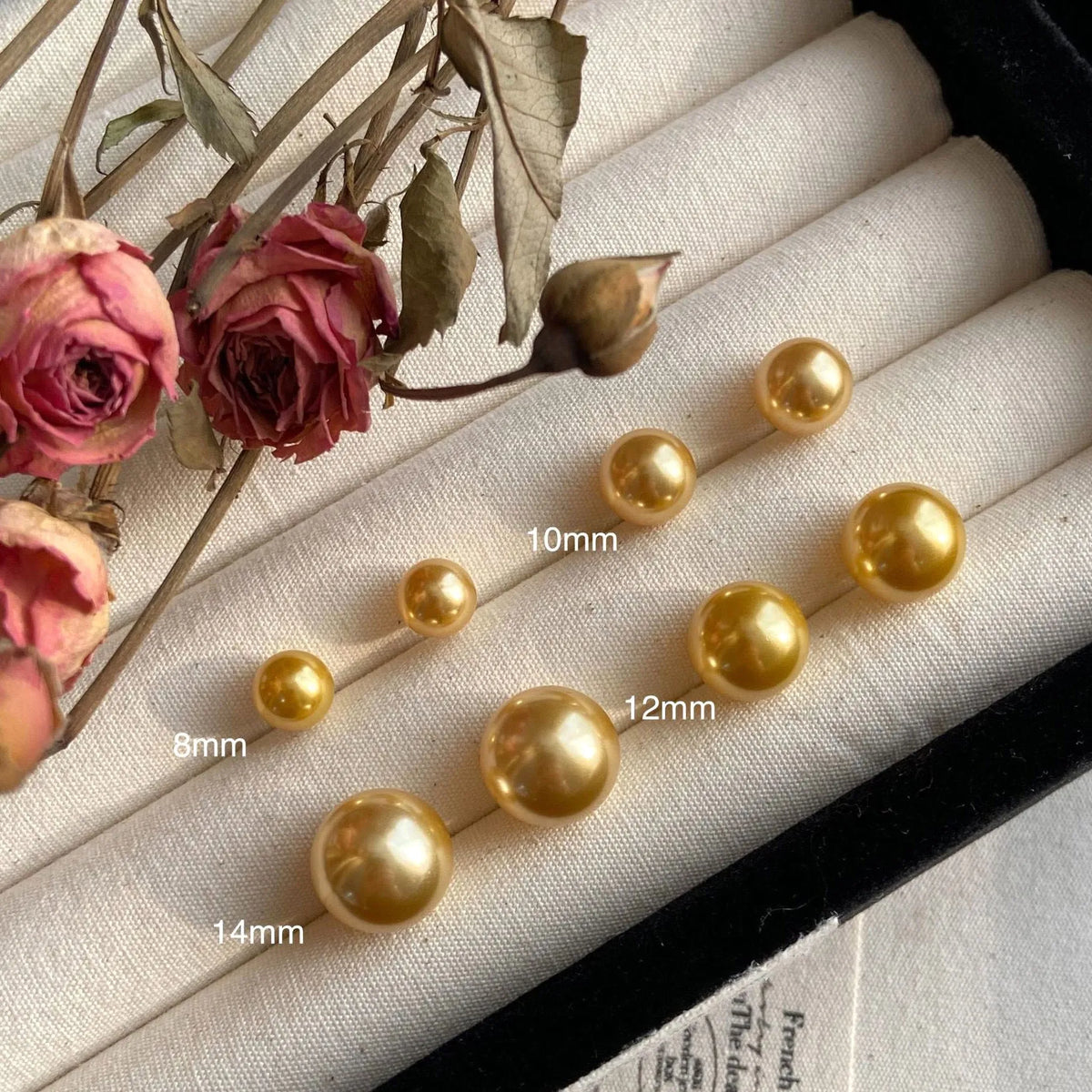 A pair of large geometric pearl stud earrings with an eight-point star detail on a silver setting.