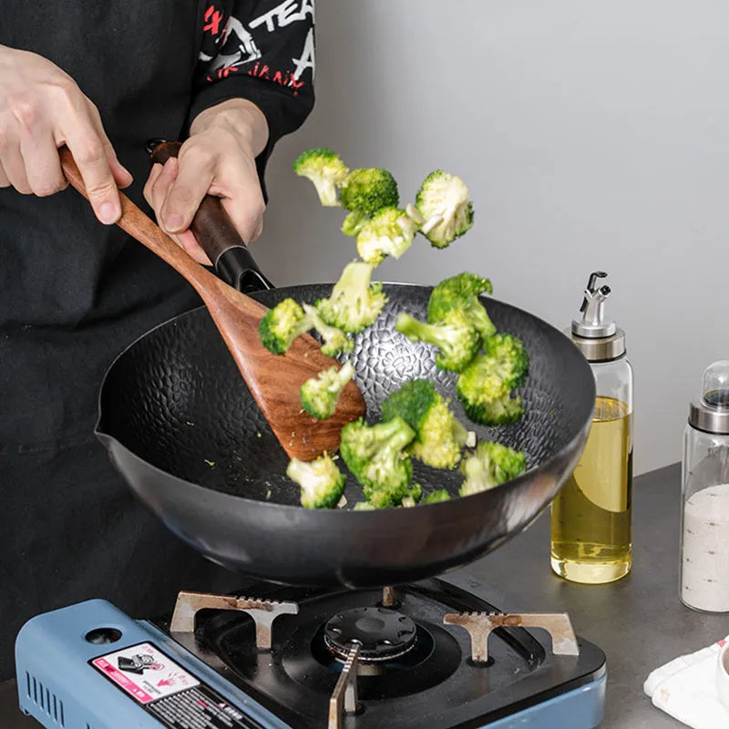 Traditional black iron wok with wooden handle measuring 32cm in diameter