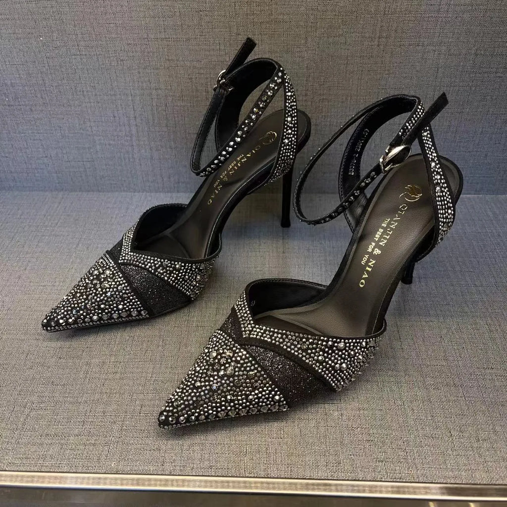 Women's silver hollow high heels with stiletto heel, pointed toe, and red sole on a plain background.