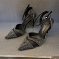 Women's silver hollow high heels with stiletto heel, pointed toe, and red sole on a plain background.