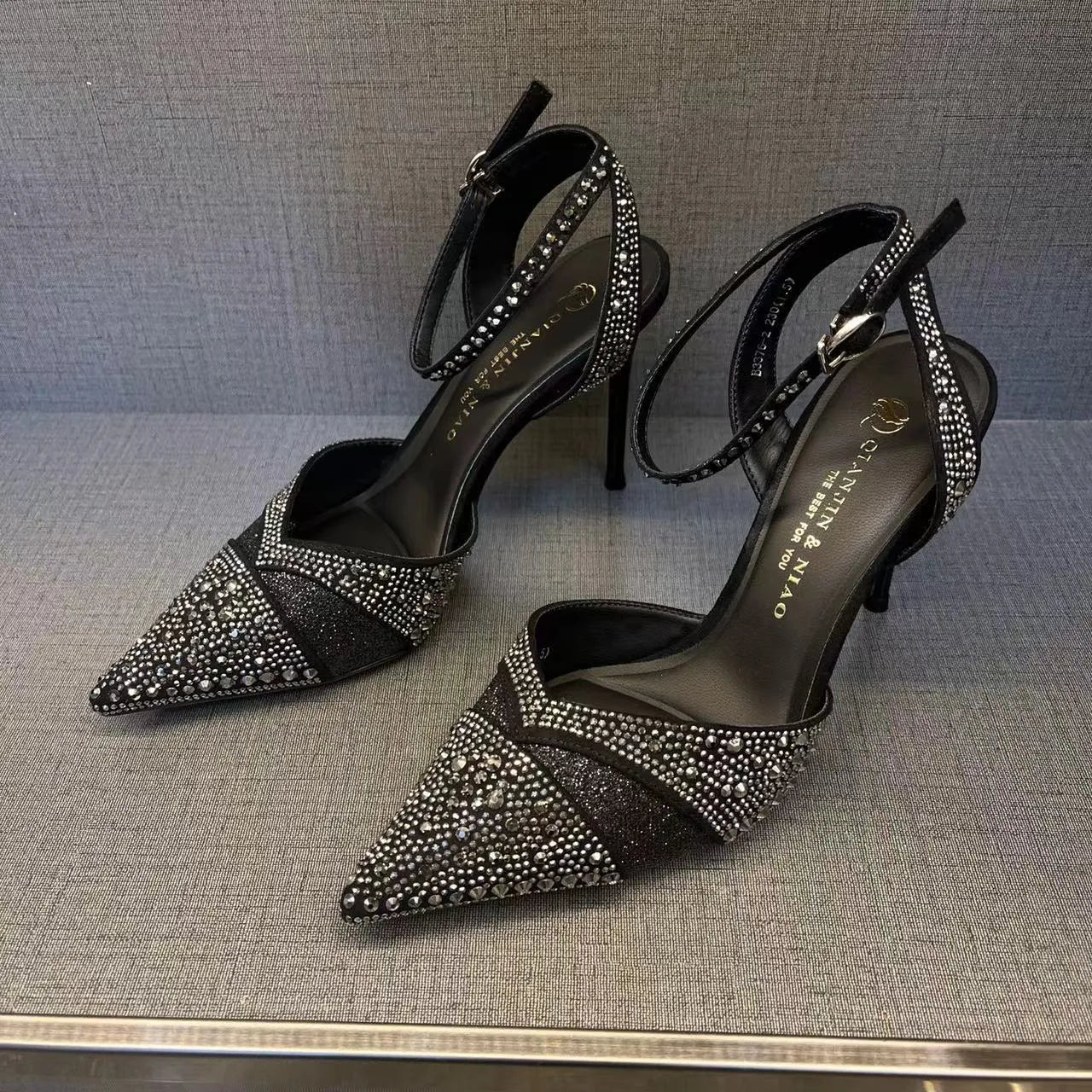 Women's silver hollow high heels with stiletto heel, pointed toe, and red sole on a plain background.