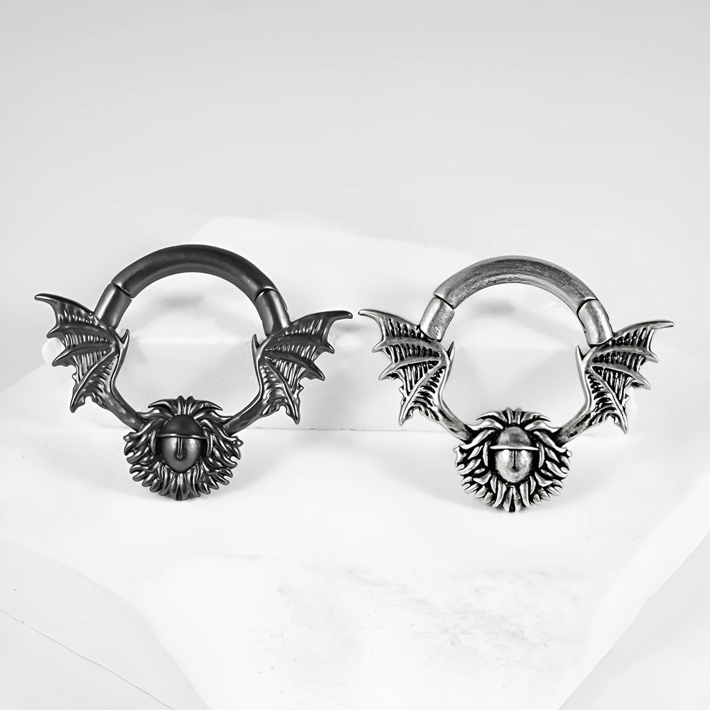 A pair of sharp cone-shaped copper ear extenders with a round magnetic closure on a flat surface.