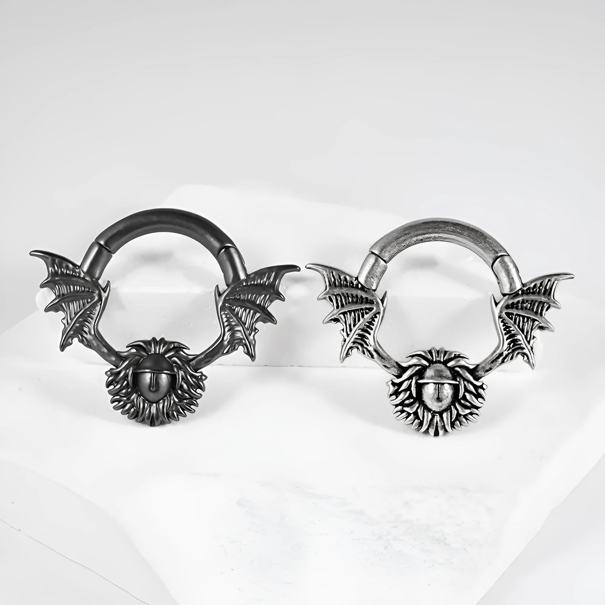 A pair of sharp cone-shaped copper ear extenders with a round magnetic closure on a flat surface.