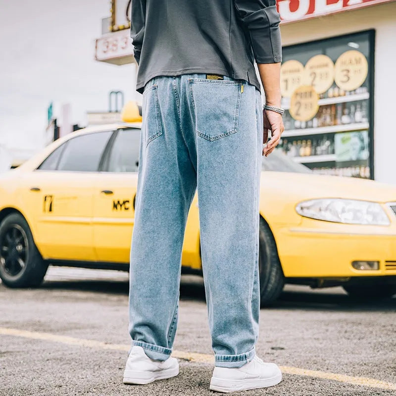 Men's loose straight leg jeans in dark blue cotton denim with a mid-rise waist and zipper fly