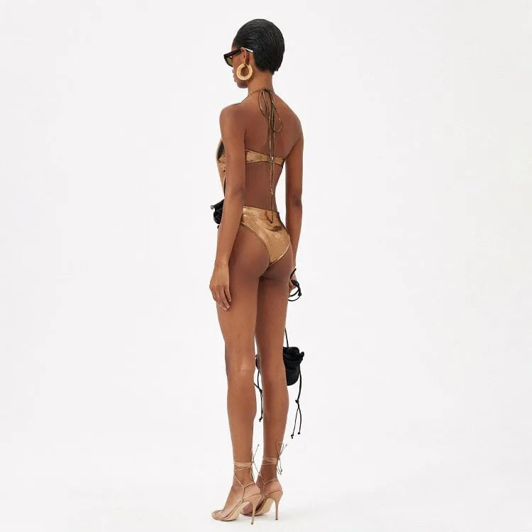 Gold handmade one-piece swimsuit with halter neck and hollow-out design on a mannequin.