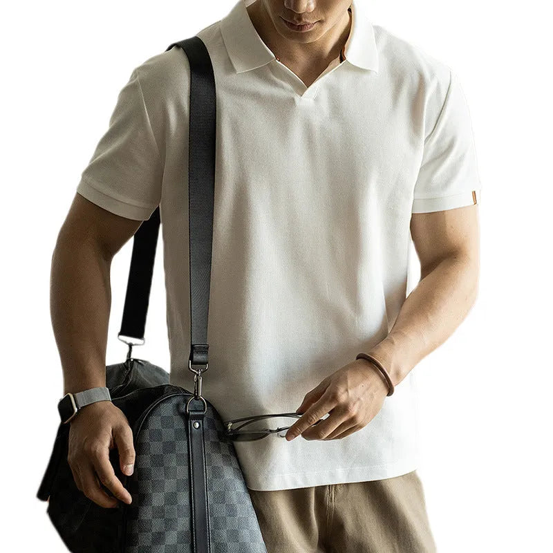 Man wearing a classic blue short-sleeved cotton blend polo shirt, showing regular fit and button placket.