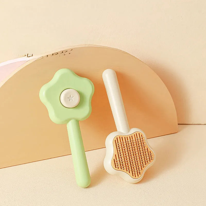 Green self-cleaning cat comb with stainless steel pins on a white background