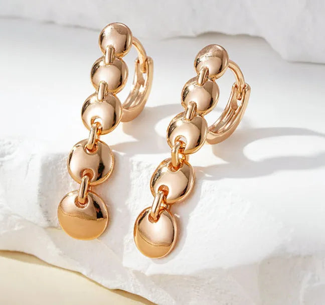 Long gold retro circle earrings with woven chain design, shown from the side.