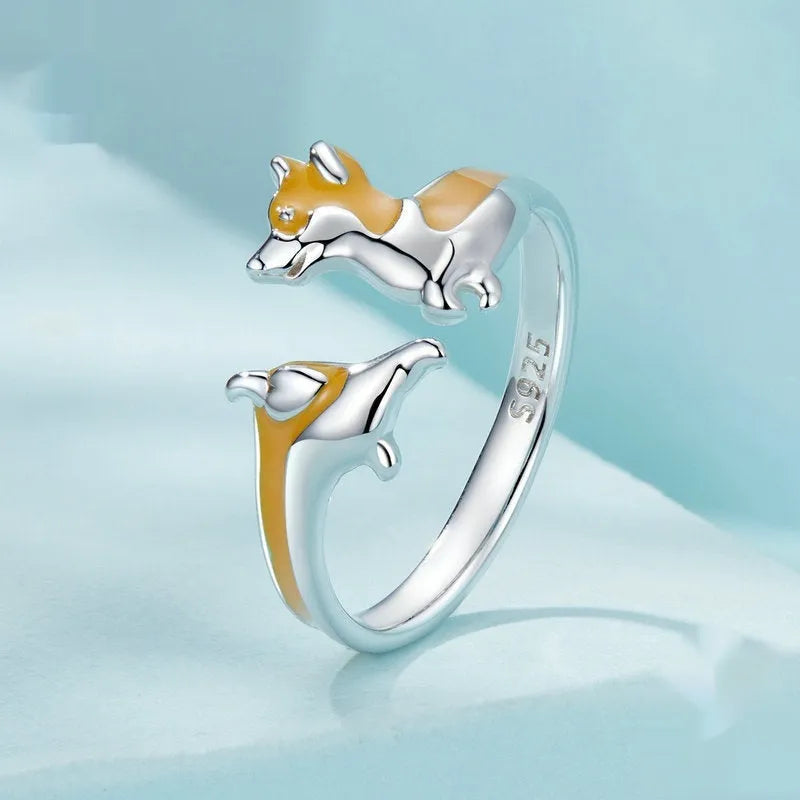Cartoon-style silver corgi dog ring on a plain background.