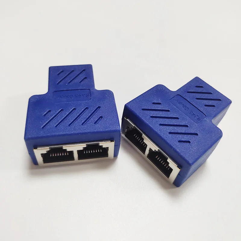 Two white RJ45 three-way network tee splitters on a table.