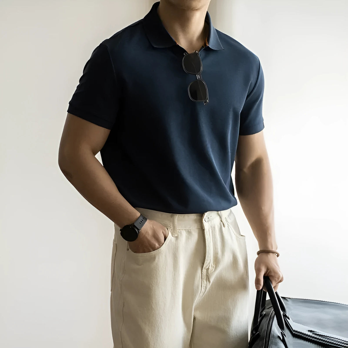Man wearing a classic blue short-sleeved cotton blend polo shirt, showing regular fit and button placket.