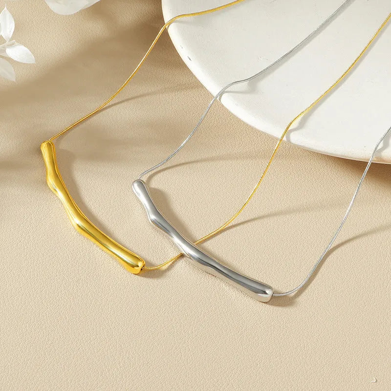 Close-up of a women's pleated titanium steel necklace in gold colour showing its textured folded design.