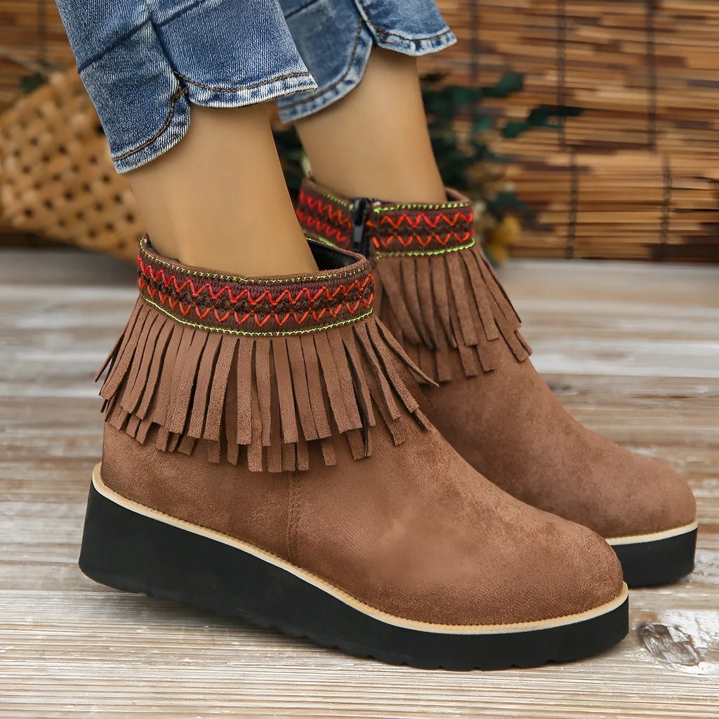 Women's dark brown suede ankle boots with thick platform wedge sole, side zip, and tassel detail.