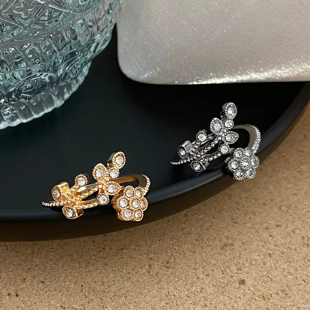 Women's open ring with diamond-treated flower and leaf design in gold colour on copper base