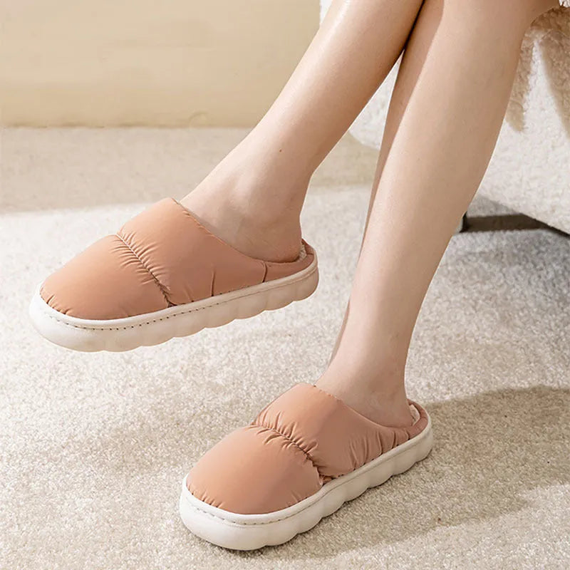 Blue down cotton slippers with artificial leather upper, thick rubber sole, and plush lining shown on a wooden floor.