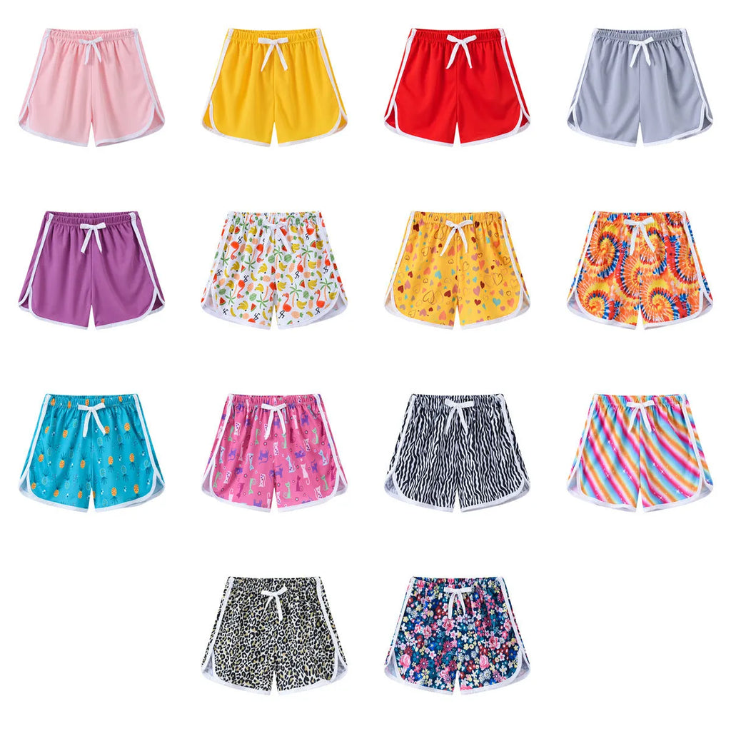 Children's colourful polyester beach shorts showing patterns like leopard print, stripes, and pineapples.