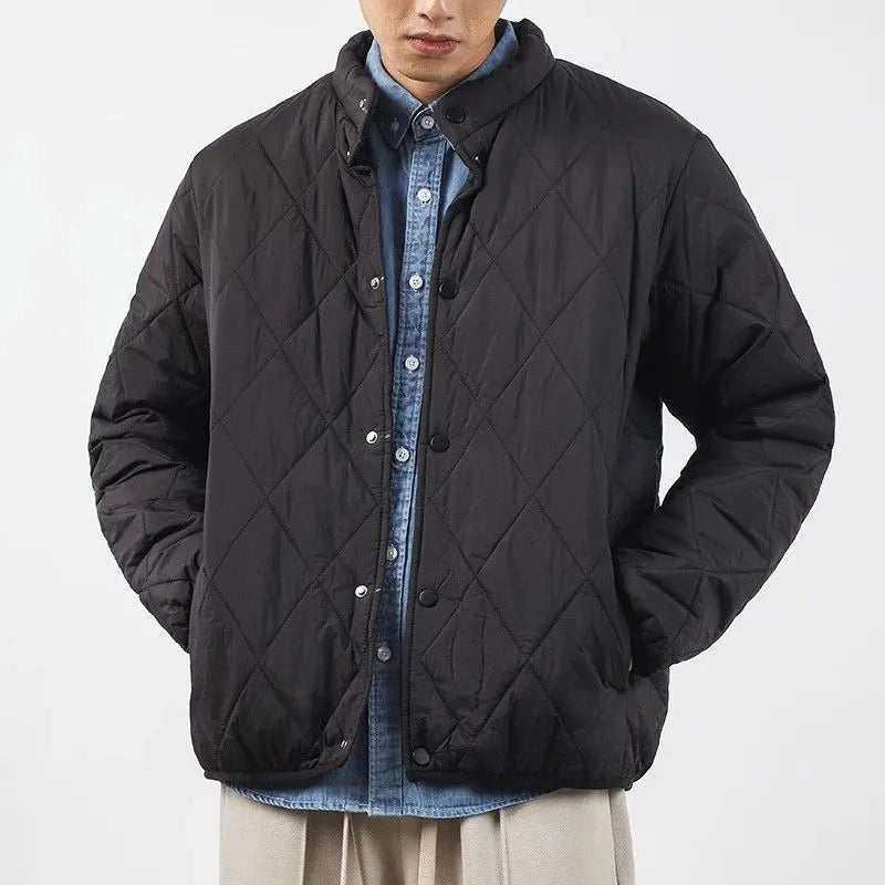 Man wearing a black diamond quilted longline winter jacket with a loose fit.