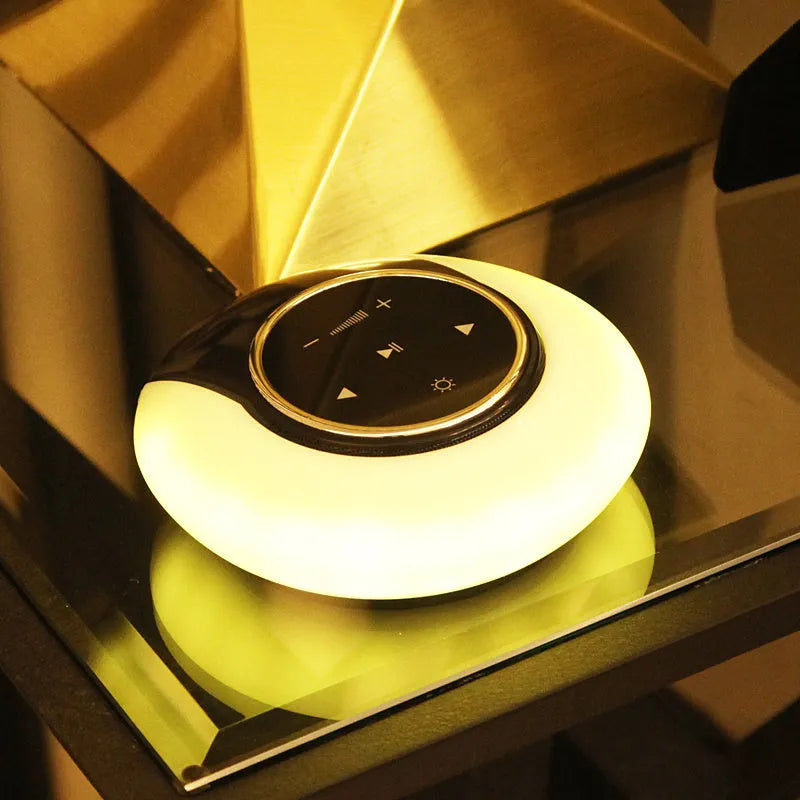 Foldable blue and white Bluetooth desk lamp with speaker, showing touch controls on a desk.