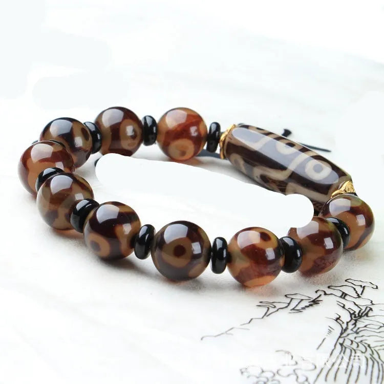 Distressed agate bracelet with traditional Tibetan dzi beads including three-eye and Nine Eyes designs.