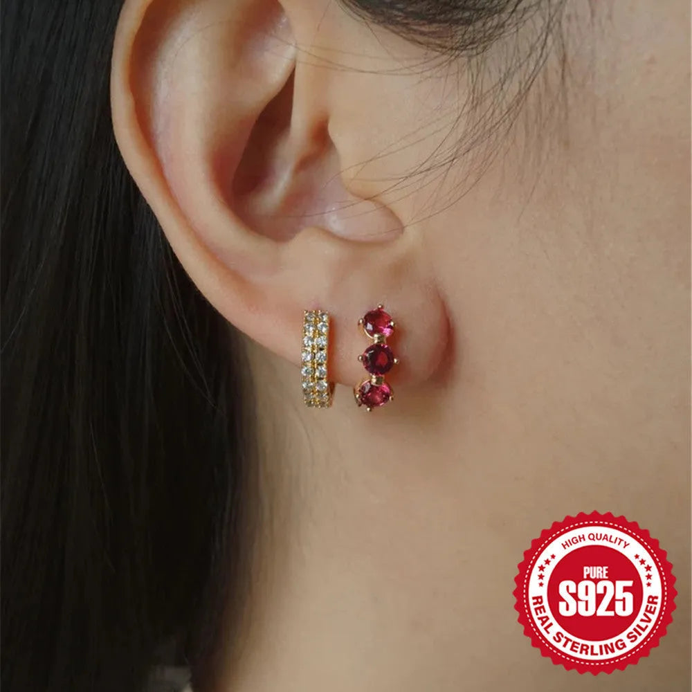 Golden coloured geometric sunflower sterling silver earrings with zircon inlay on a white background.