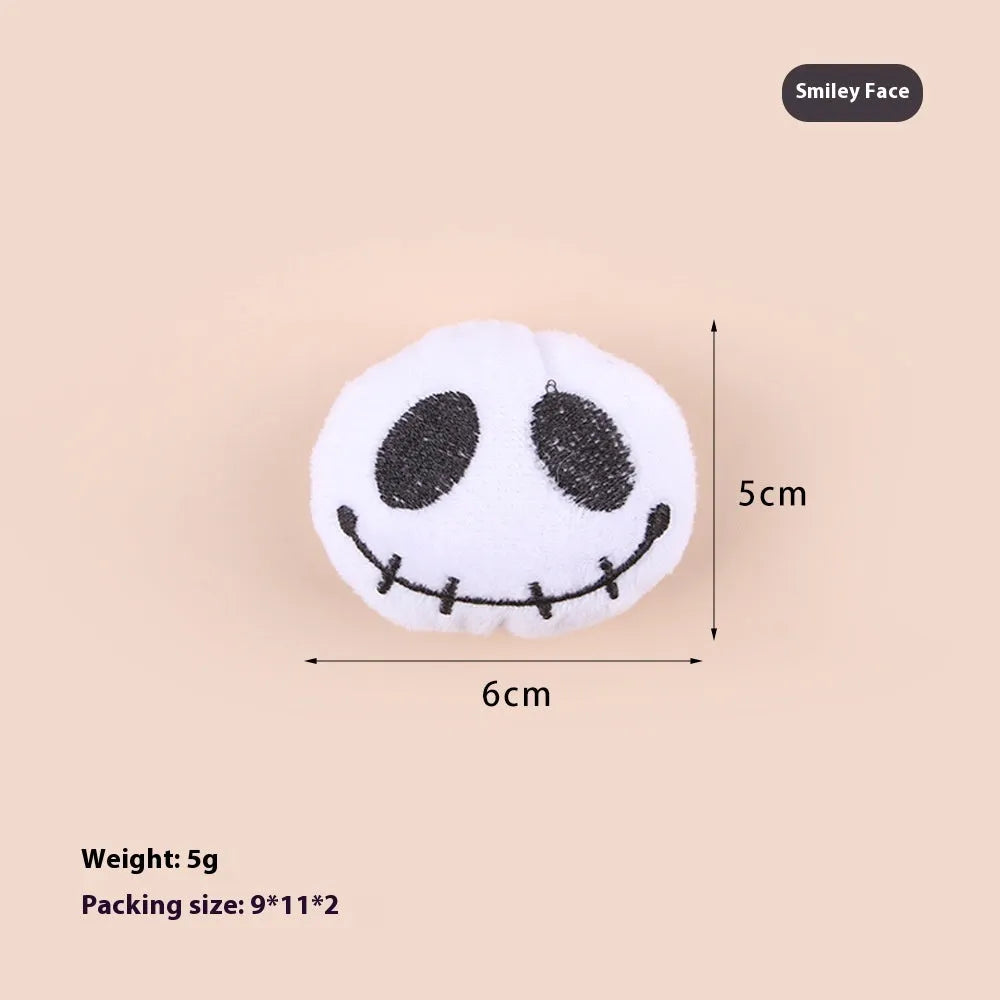 Small plush cat teaser toy in candy, eyes, and skull designs on a blue background.