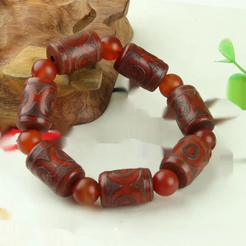 Distressed agate bracelet with traditional Tibetan dzi beads including three-eye and Nine Eyes designs.