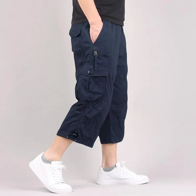 Man wearing loose, cropped cotton casual pants in army green, suitable for sports.