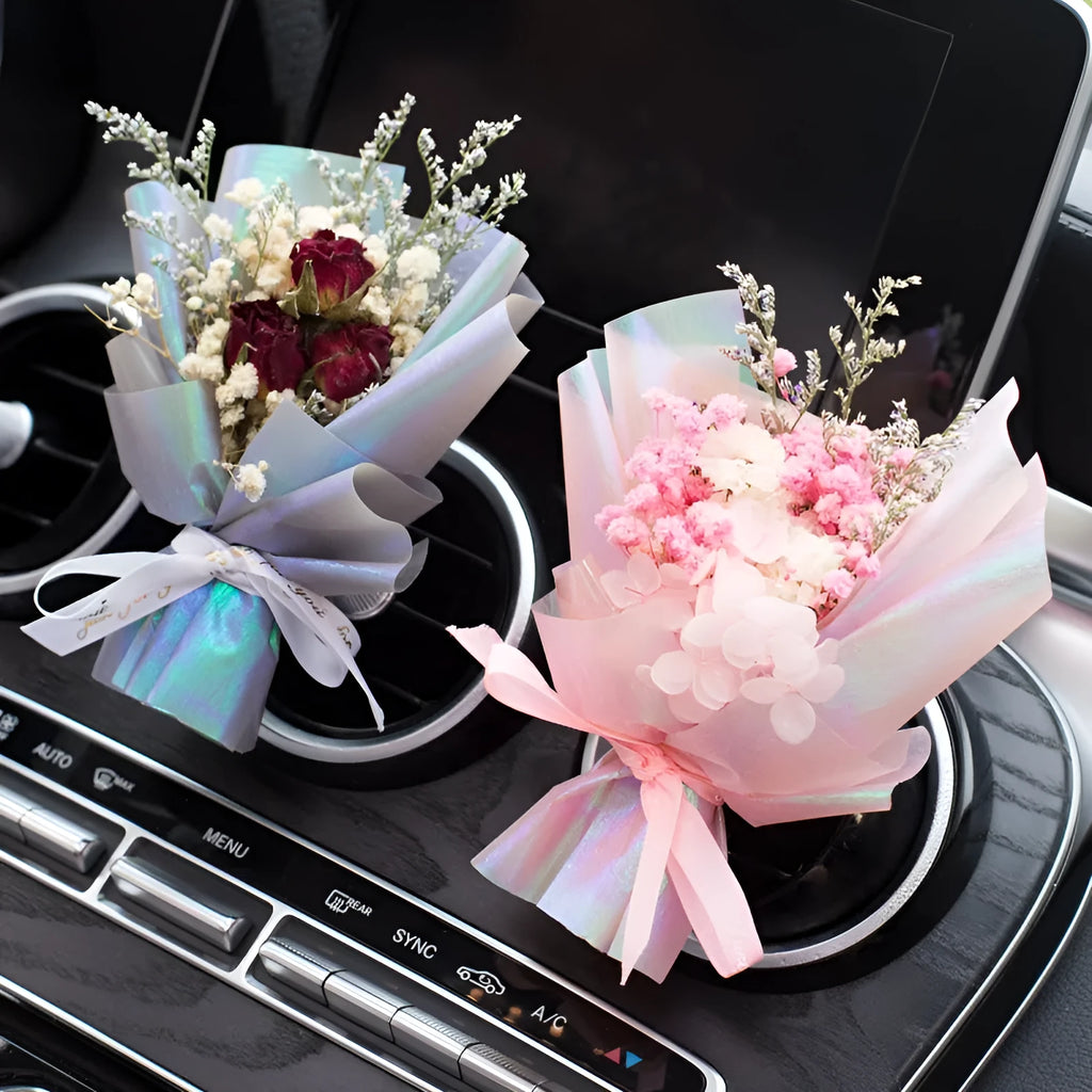 Handmade dried flower car air freshener ornament clipped to a car vent, showing colour and natural material detail.
