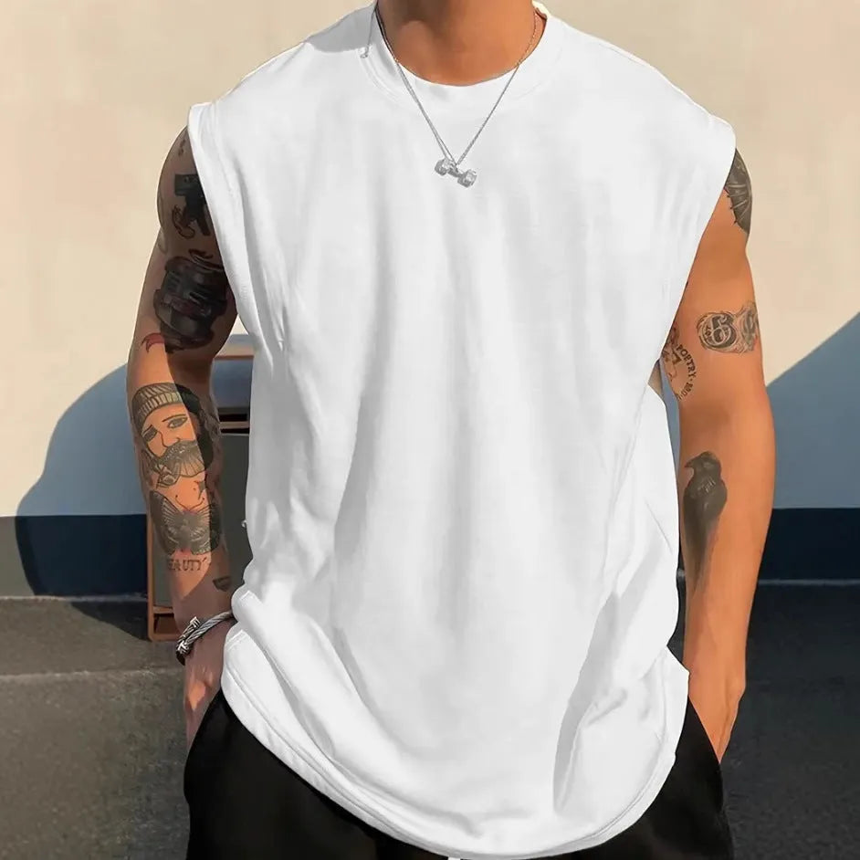 Man wearing a loose apricot-coloured cotton tank top, showing the sleeveless design and straight hem.