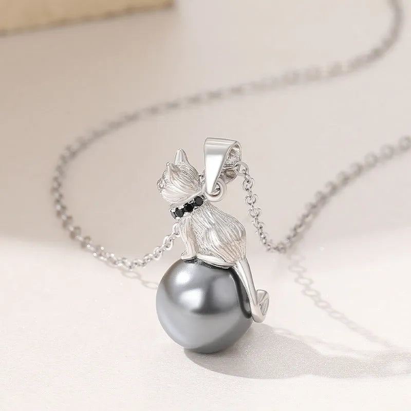 Close-up of a sterling silver cat pendant necklace on a clavicle chain.