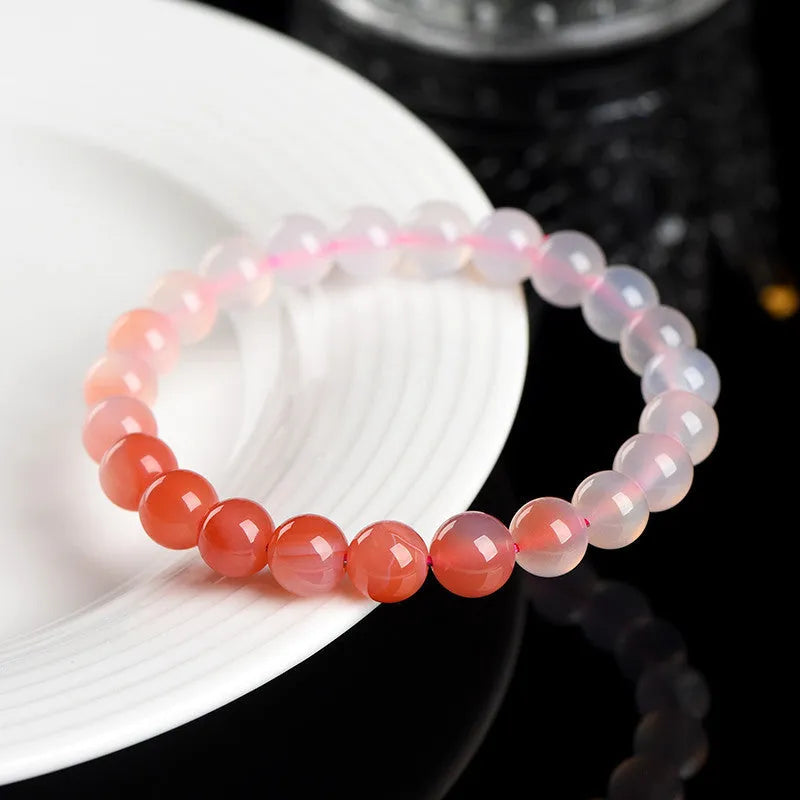 Natural gradient Yanyuan agate bracelet with geometric beads on a wrist, showing colour variation.