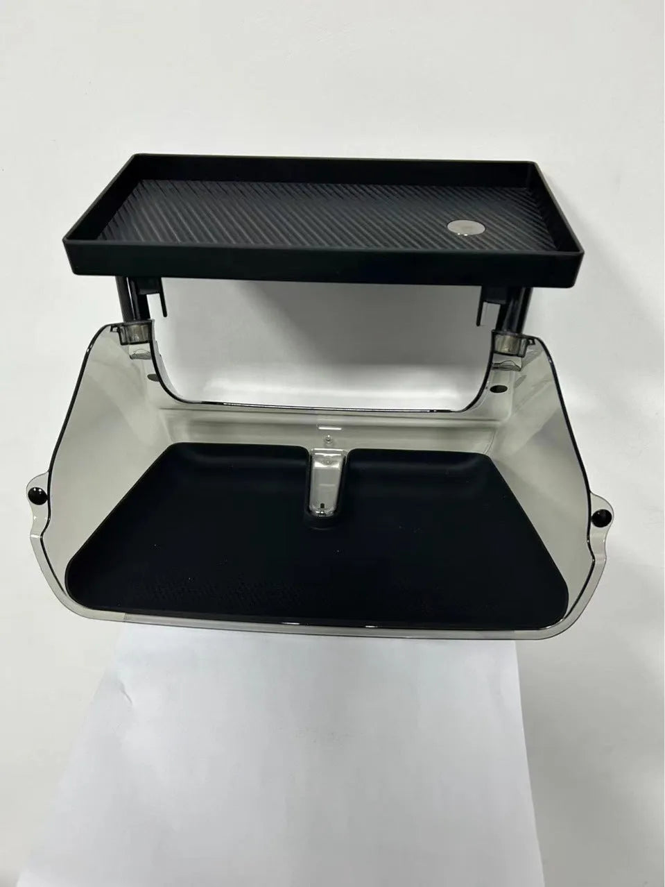 Black ABS plastic storage box installed under the touchscreen in a Tesla Model Y centre console.