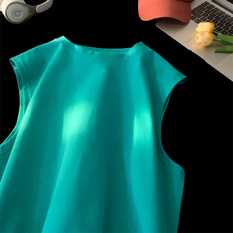 Man wearing a loose apricot-coloured cotton tank top, showing the sleeveless design and straight hem.