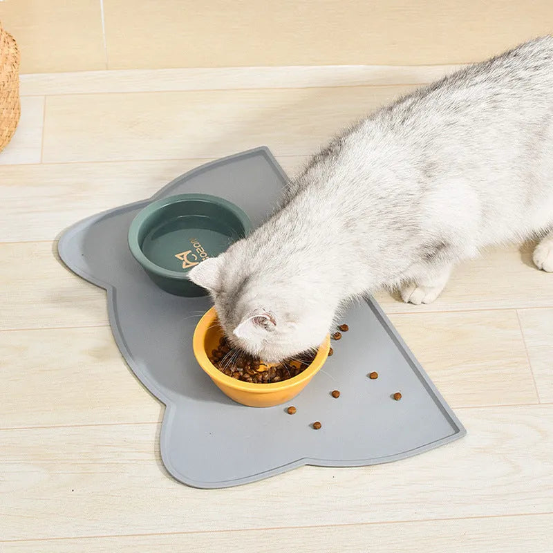 Blue silicone pet feeding mat with cat head shape under dog bowl