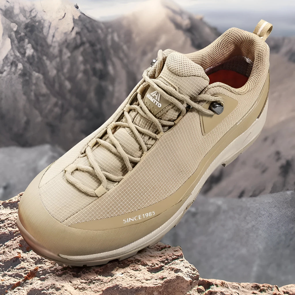 Low-top hiking boots in black with leather mesh upper, rubber outsole, and front lace-up design on a neutral background.