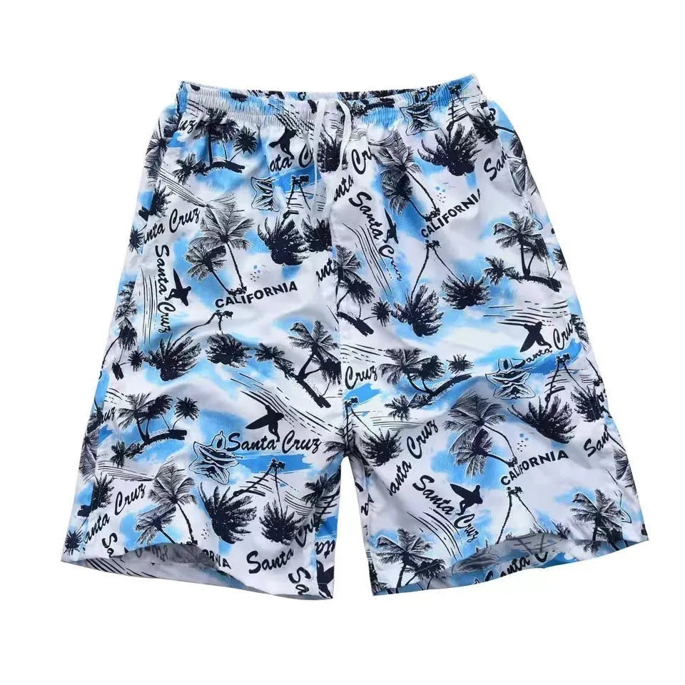 Man wearing floral print swimming trunks at the beach, showing the loose fit and colourful pattern.
