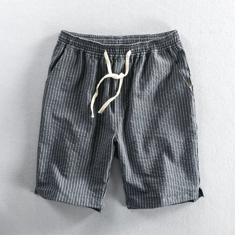 Man wearing striped casual cotton shorts with a loose straight fit and elasticated mid waist.