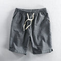 Man wearing striped casual cotton shorts with a loose straight fit and elasticated mid waist.