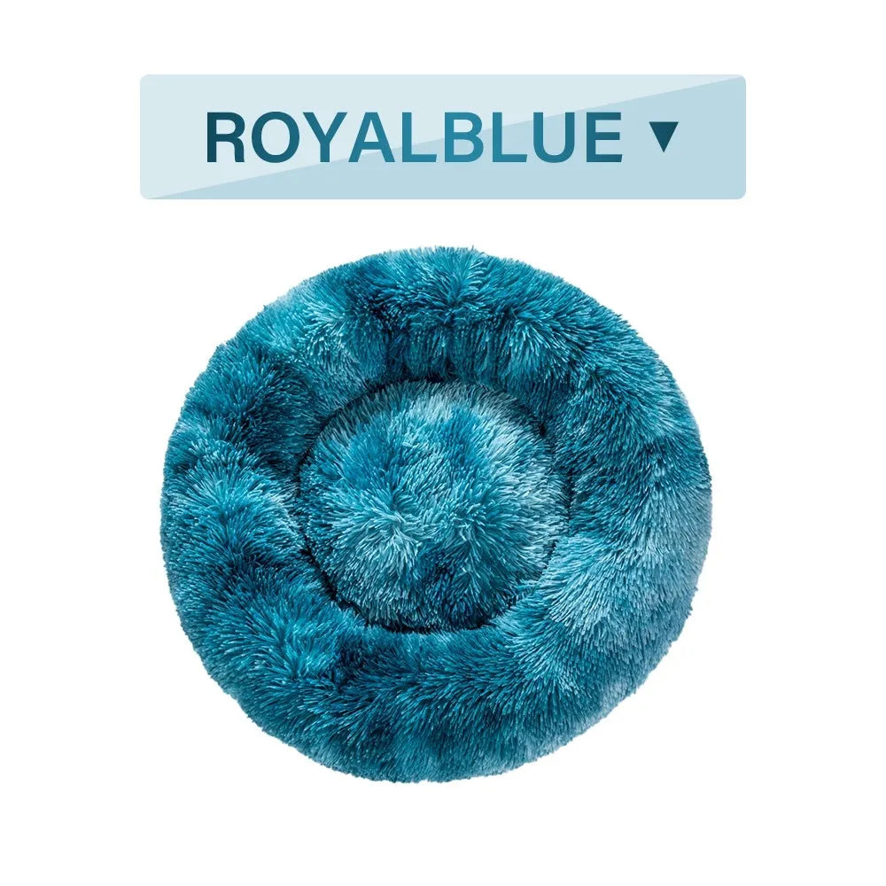 Fluffy donut-shaped dog bed in long plush material, showing raised rim and central cushion.