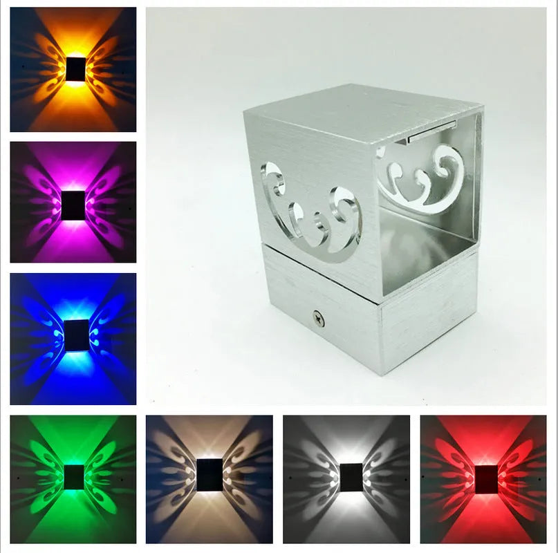 Modern aluminium butterfly-shaped LED wall lamp with remote control on a plain background.