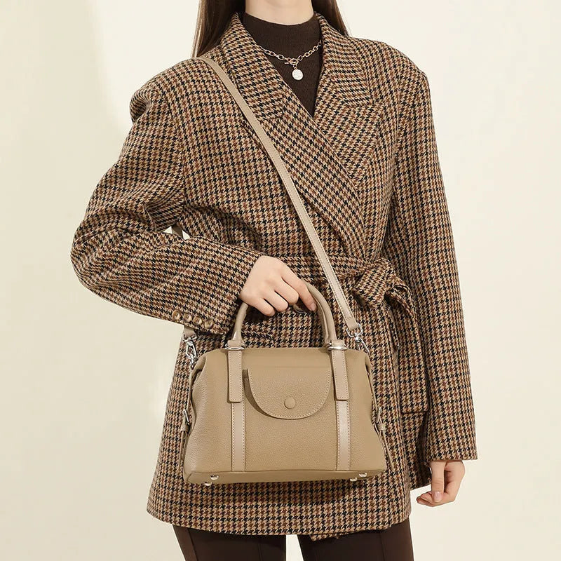 Genuine leather ladies handbag with contrast stitching and lock detail in elephant grey colour