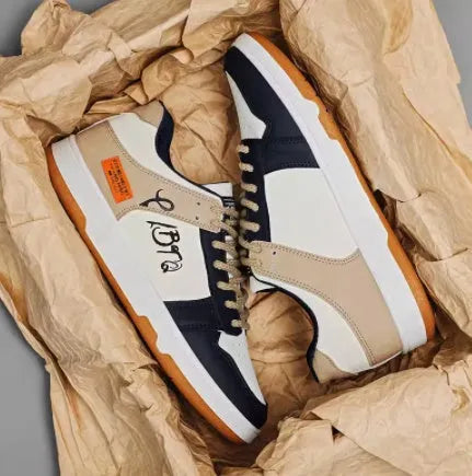 A pair of plain white and blue lace-up casual sneakers on a neutral background.