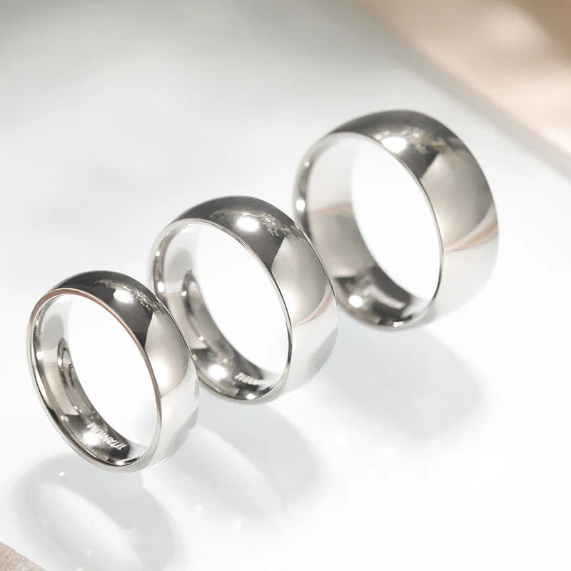 A silver titanium steel ring with a matte grinding finish, shown in different band widths on a plain background.