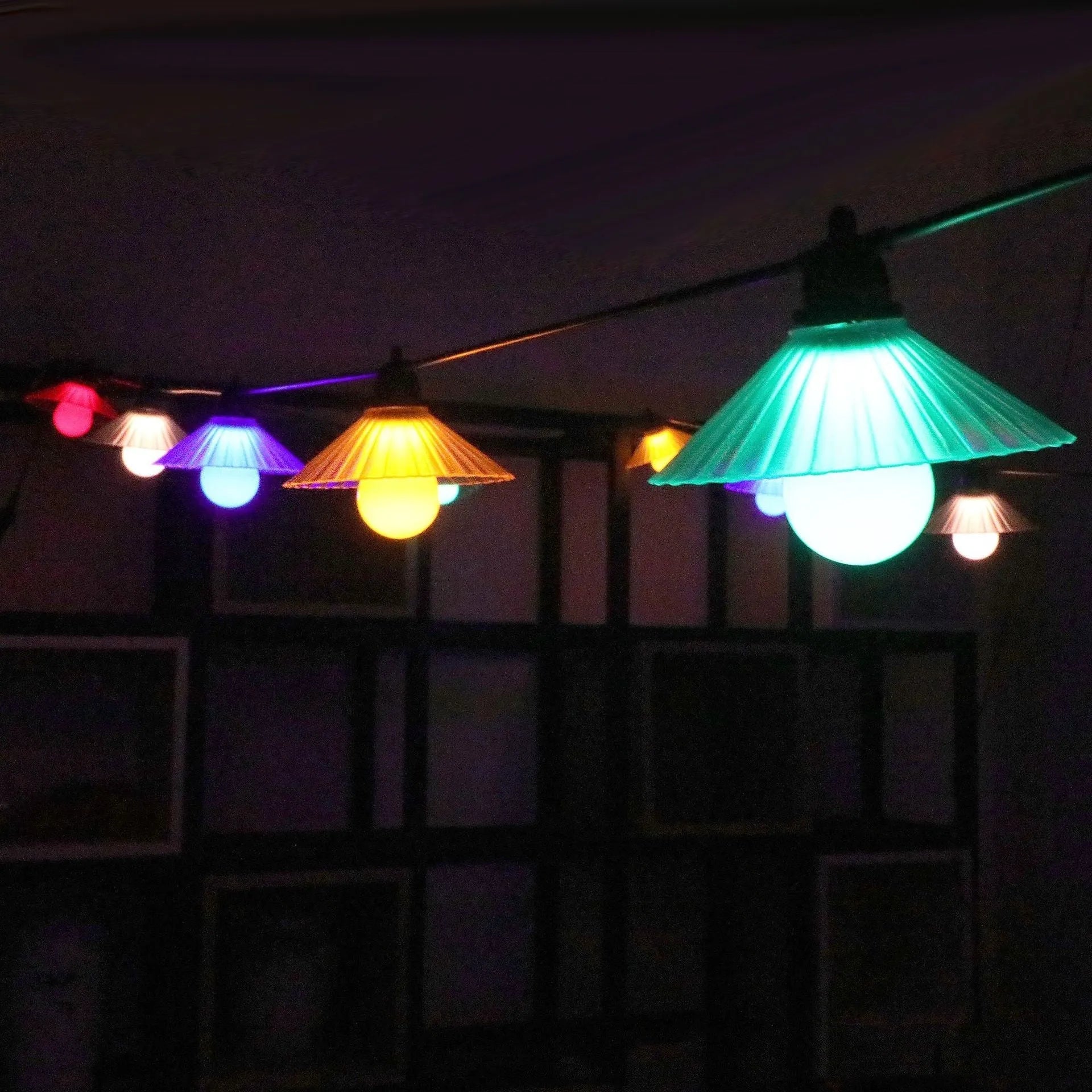 Outdoor flower-shaped LED string lights with IP65 rating hung in a garden setting.