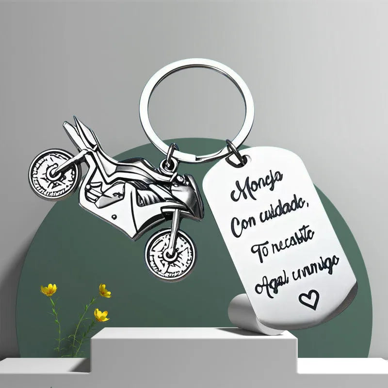 Stainless steel motorcycle key chain with charm and grey flannel storage bag.