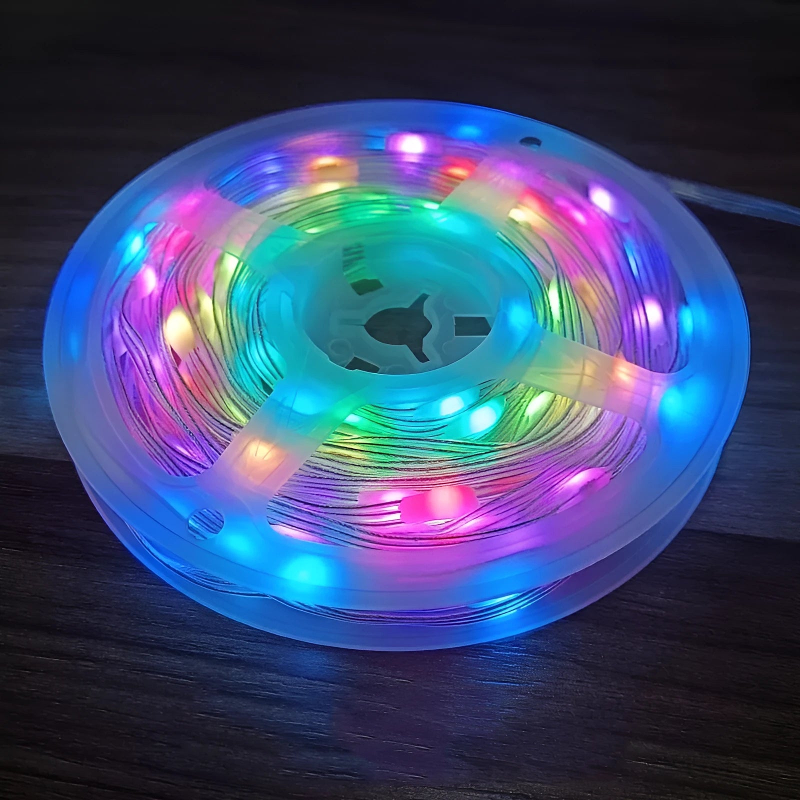 10 metre long LED festival light string with 100 warm white bulbs coiled on a table next to its remote control.