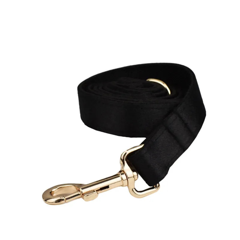 A cloth dog collar, matching leash, decorative bow, and dog vest set laid out flat, showing the coordinated design.
