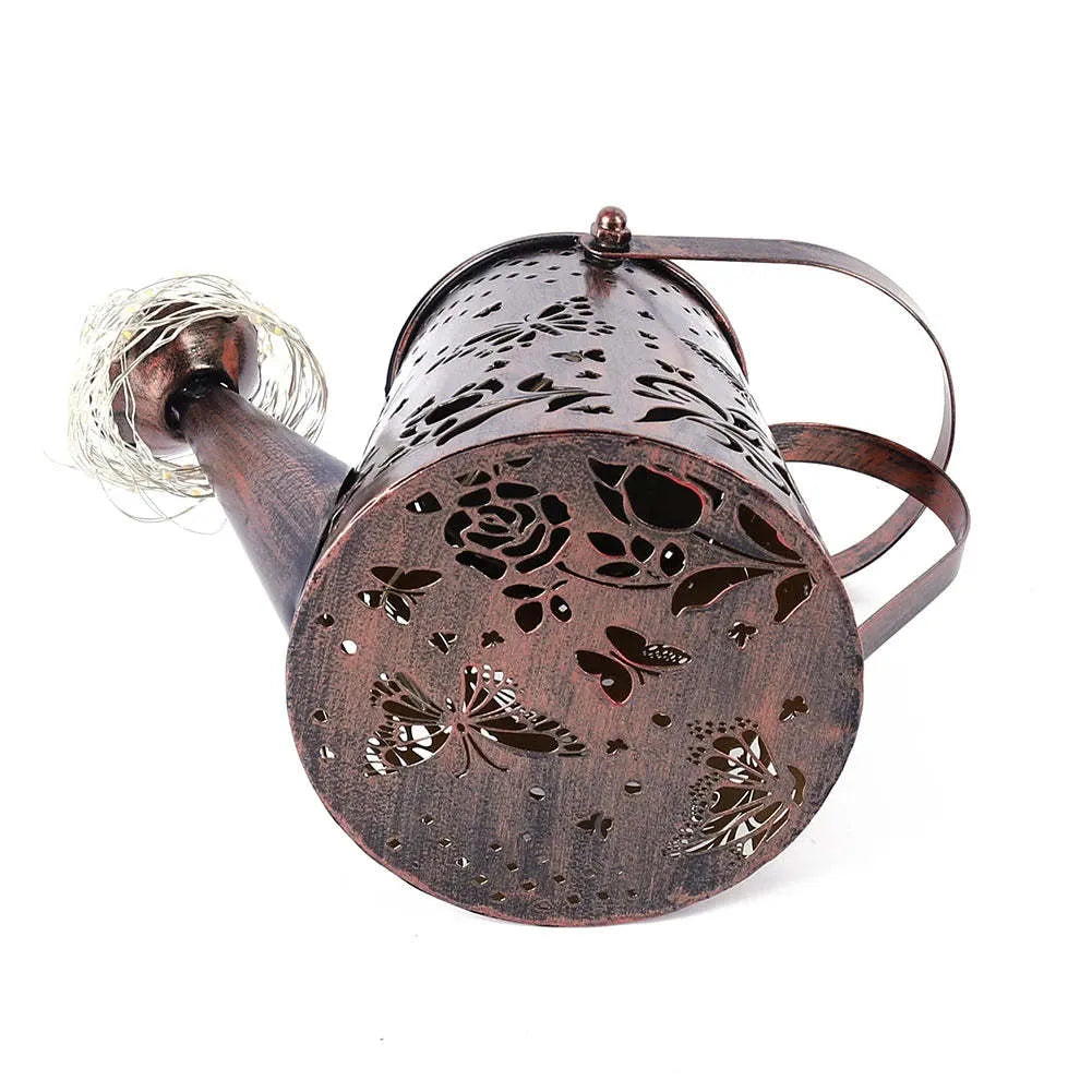 Tapered iron solar garden lamp with butterfly pattern emitting warm white light in a courtyard setting