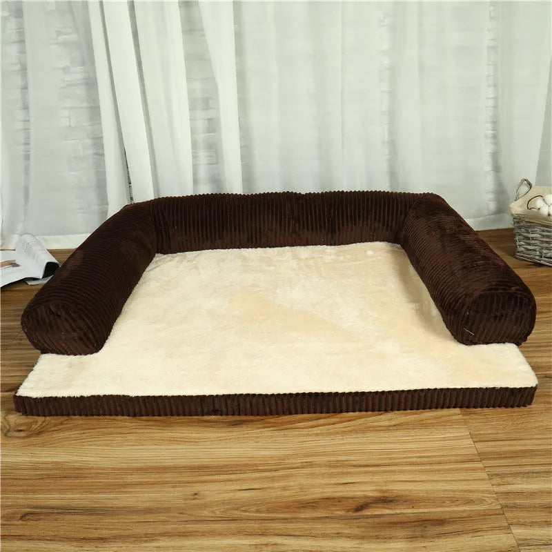 Corduroy pet sofa dog bed with a raised bolster, shown in a grey colour on a wooden floor.