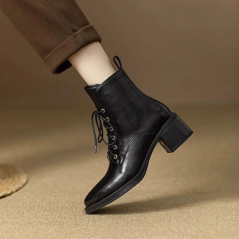 Women's black pointed toe short tube boots with 5.5cm heel on wooden floor